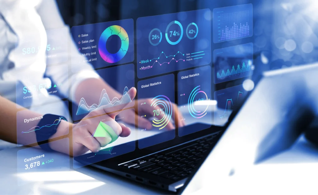 Mano interactuando con un panel holográfico de gráficos circulares, de barras y líneas sobre un portátil