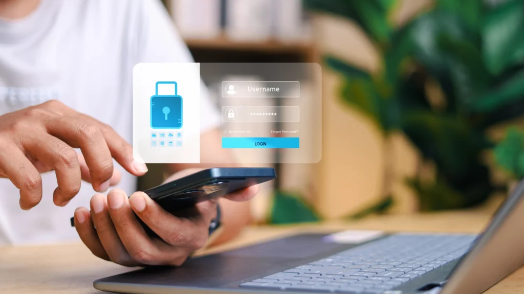 Hombre usando smartphone con pantalla de inicio de sesión segura junto a un portátil